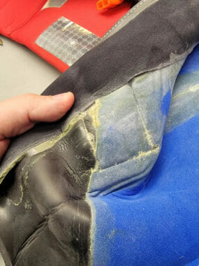 A close-up of part of a survival suit showing a seam separating