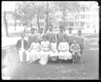 A very old, black and white group photo taken outside