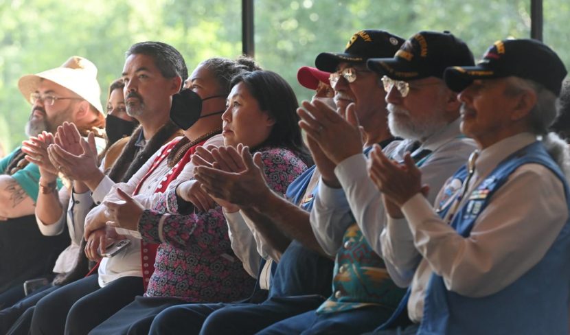 A row of people sitting in chairs and clapping
