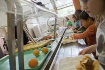 Schoolchildren with trays getting a cafeteria meal