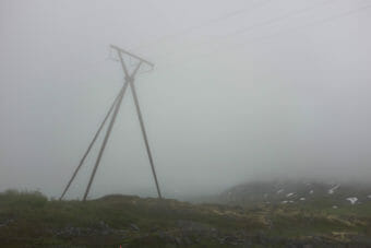 A power line in the mountains in heavy fog