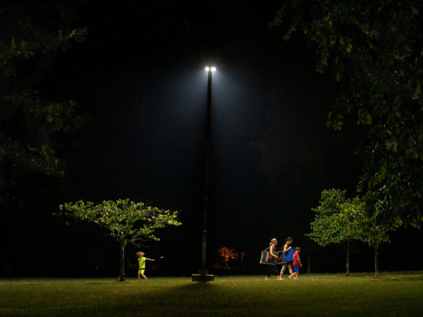 People walking through a park at night
