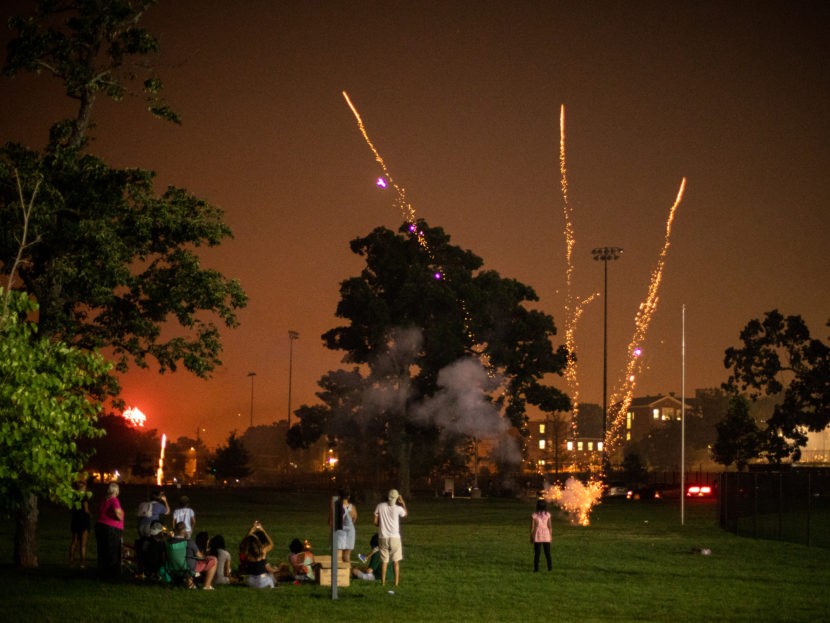 People setting off fireworks in a park