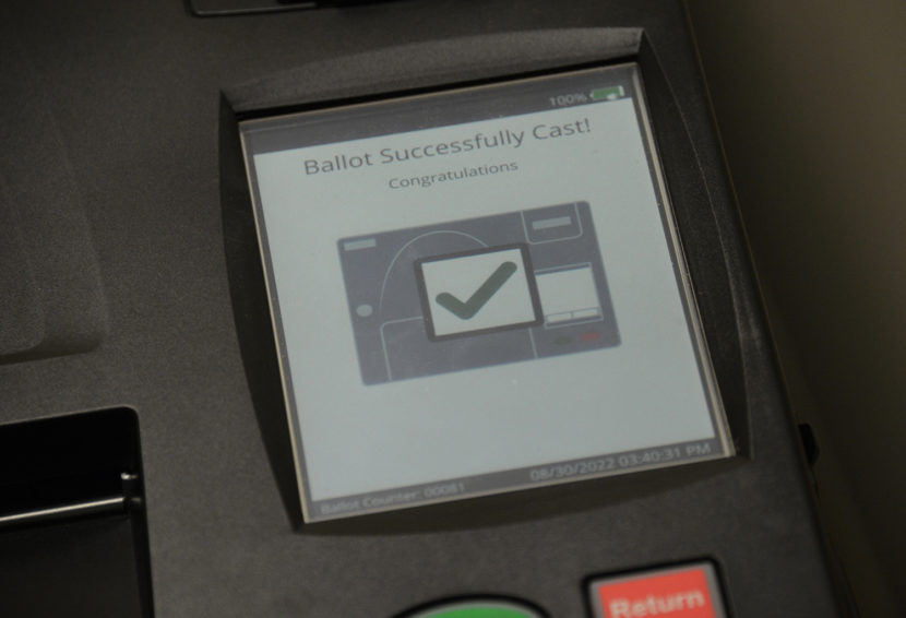 A screen on a ballot scanner shows the message "ballot successfully scanned! congratulations"