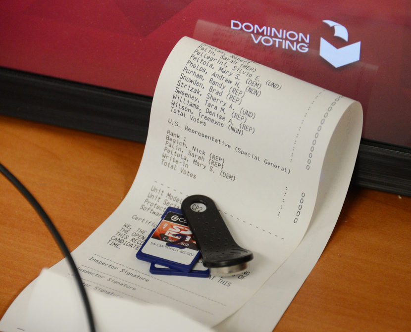 A folded receipt tape with SD memory cards and a small tool on top of it
