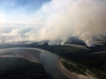 Aerial photo of smoke rising from fires on a section of tundra laced with rivers and streams