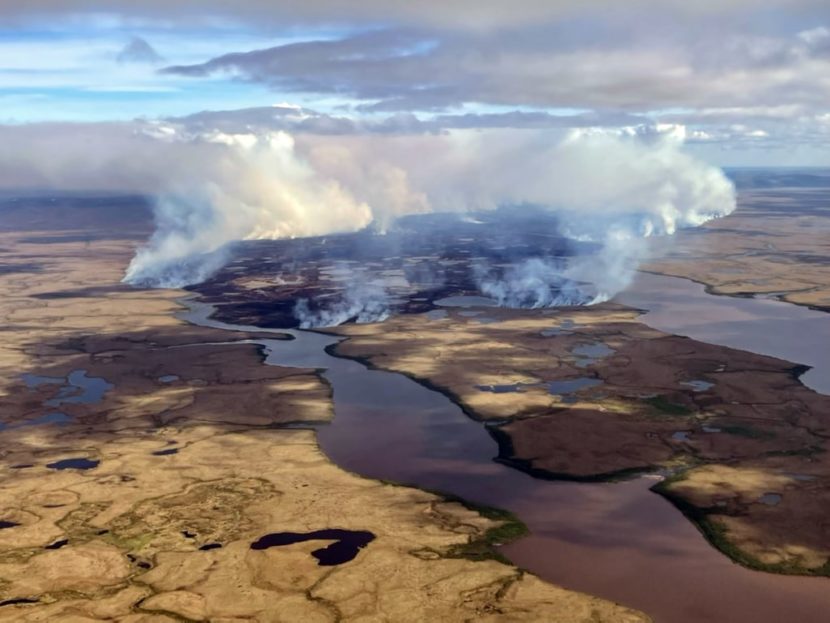 An aerial photo of smoke over a tundra fire