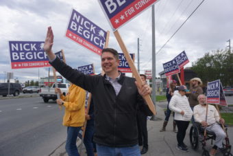 Nick Begich and supporters wave campaign signs by the road