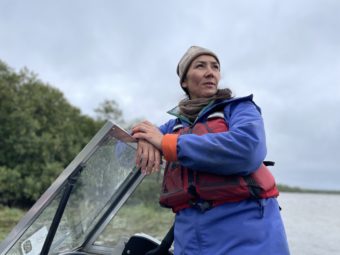 Mary Peltola stands at the wheel of a small boat