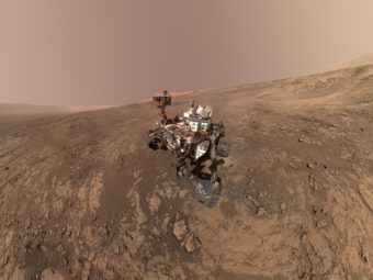 The mars rover on a barren red hillside