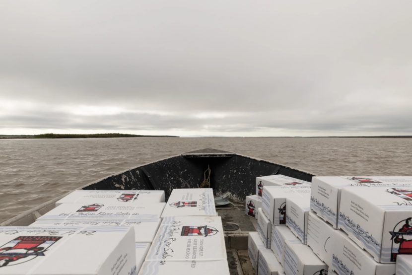 The bow of a boat filled with white cardboard boxes