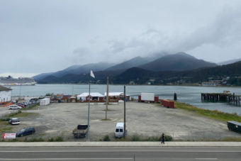 A large, mostly empty waterfront lot with Gastineau Channel in the background