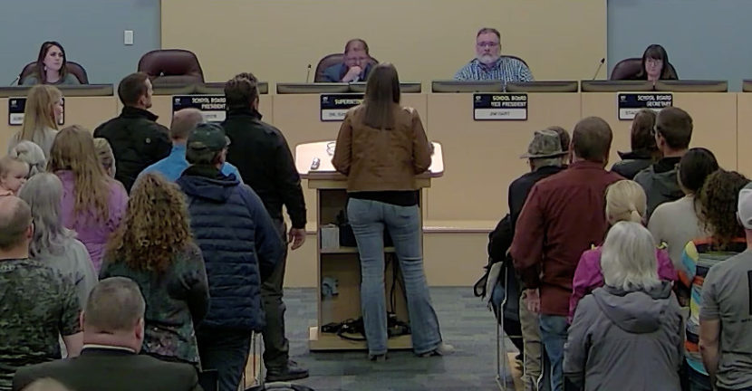 A screenshot of the live feed of a public meeting, with one person standing at a lectern to give public comment