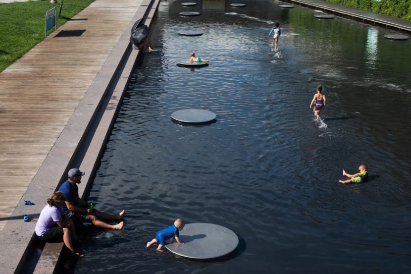 Children play in a reflecting pool