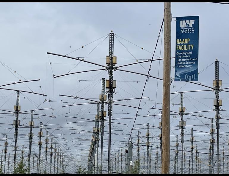 A University of Alaska banner on a pole in a the HAARP antenna field