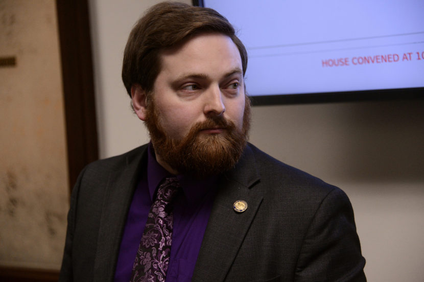 A man with a full beard wearing a paisley tie over a purple shirt