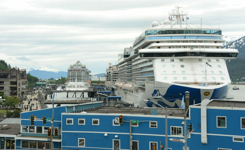 Two cruise ships towering over buildings along Juneau's waterfront