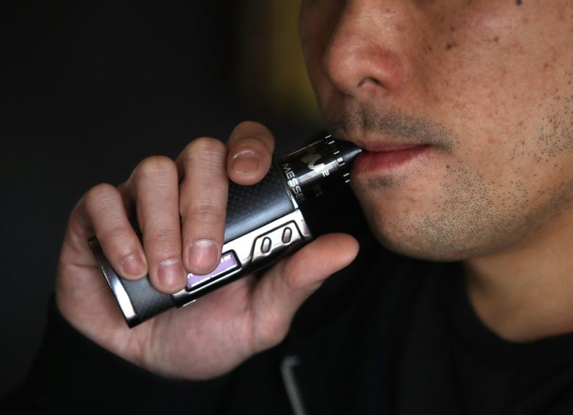 A man inhales from an e-cigarette