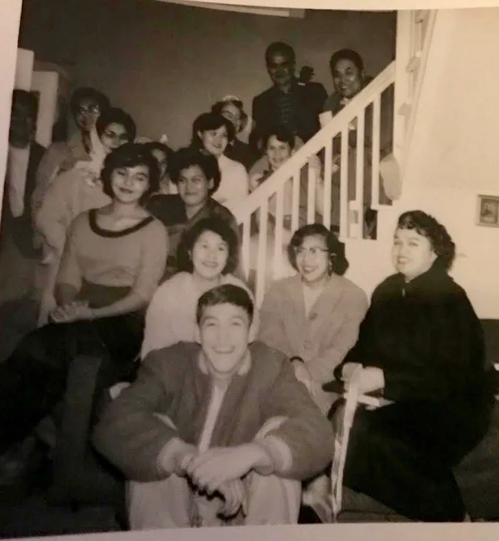 A black-and-white photo of a large group of people in church clothes posing on a staircase