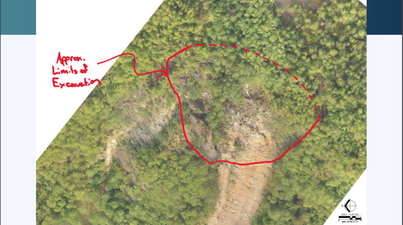An aerial image looking down at the top of a mountain, with an area of unstable rock circled in red