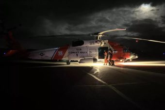 A Coast Guard helicopter on tarmac at night