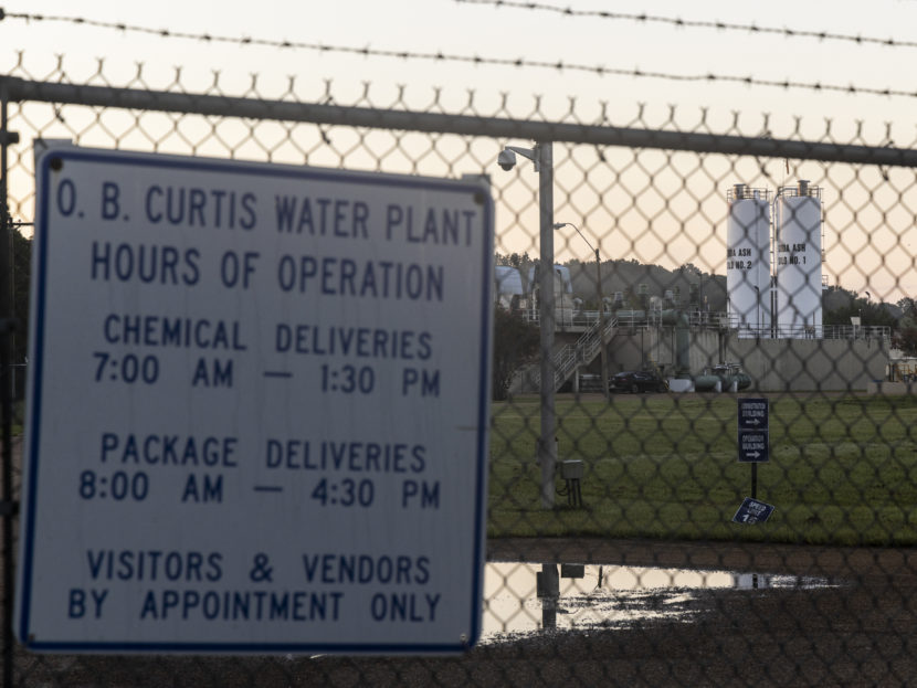 a sign on the fence outside a water treatment plant