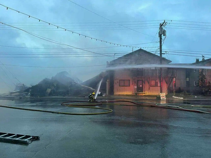 Firefighters pour water on the ruins of a building right next door to the Nome Nugget Inn