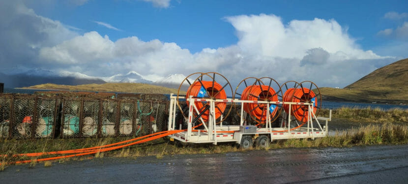 Spools of orange fiberoptic cable by a road in Unalaska.