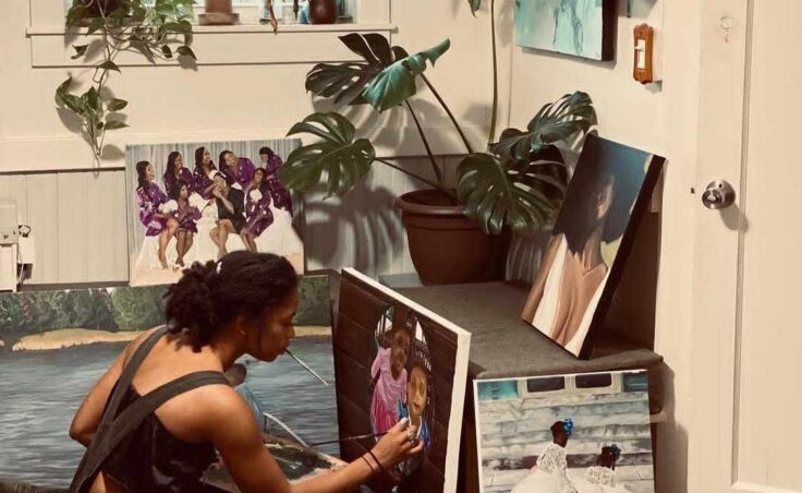 Painter Jennifer gross seated on the floor working on a painting.