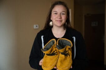 a woman holds moccasins