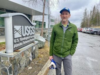 Man in green jacket in front of a USGS sign