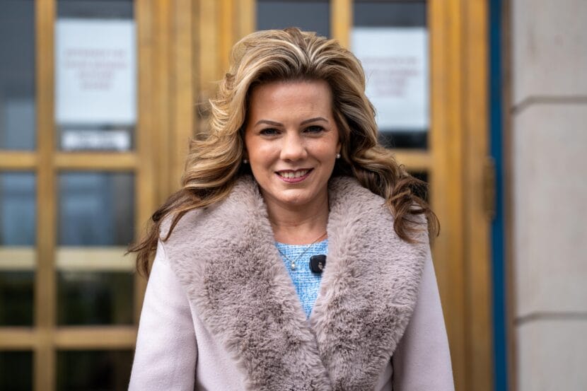 woman standing in front of metal and glass doors