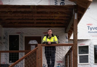 Samuel Hatch, a new plaintiff in the case, stands on the porch of his home on Meander Way. (Photo by Alix Soliman/KTOO)