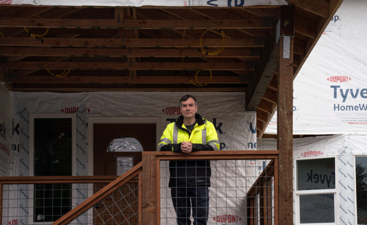 Samuel Hatch, a new plaintiff in the case, stands on the porch of his home on Meander Way. (Photo by Alix Soliman/KTOO)