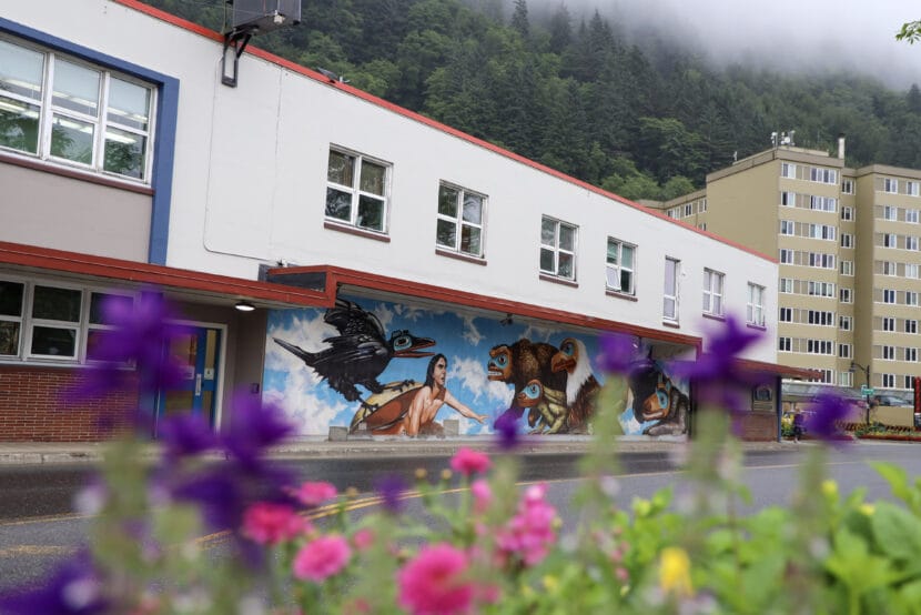 Flowers are blurry in the foreground of the side of the City Hall building that faces Egan Drive.