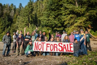 Residents of Prince of Wales Island gather on a remote beach at Port Protection on June 21, 2025, to urge lawmakers to keep public lands in public hands. (Photo courtesy of Colin Arisman)