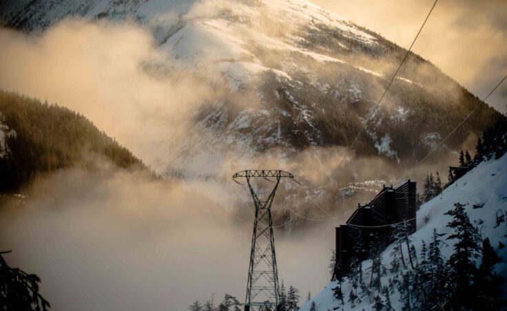 A tower and avalanche diversion wall on the Snettisham transmission line. (Photo courtesy of Mike Janes/AEL&P)