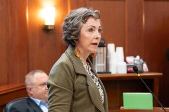 woman speaking in wood-paneled Senate chamber
