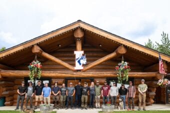Mushers pose for a photo at the Iditarod Trail Committee's 2026 sign-up event.