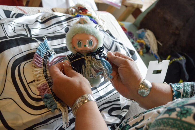 A Labubu wears Trans Pride Ravenstail regalia, woven by Masterweaver Lily Hope. Sept. 12, 2025. (Photo by Yvonne Krumrey/KTOO)