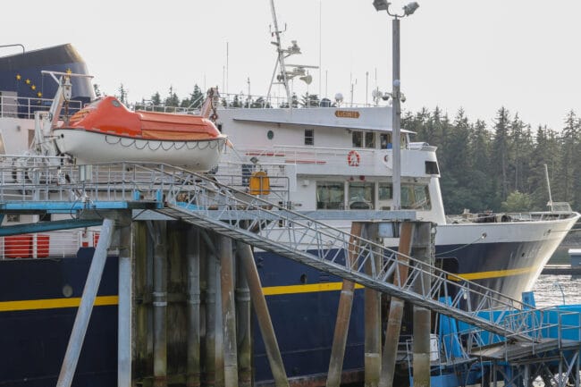 A white, blue and yellow ship with an orange raft hanging off its side. A small sign with the name "LeConte" is on the side of the ship.