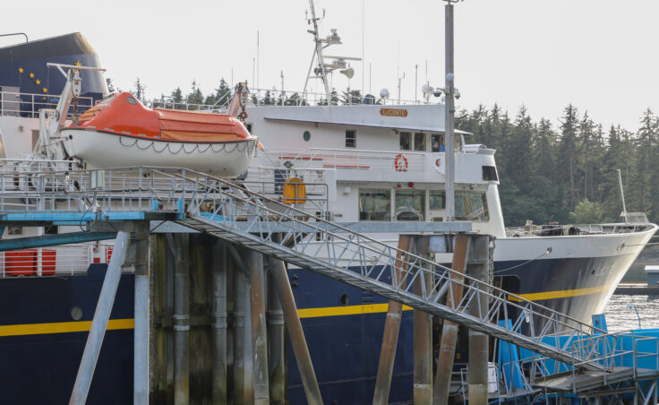A white, blue and yellow ship with an orange raft hanging off its side. A small sign with the name "LeConte" is on the side of the ship.