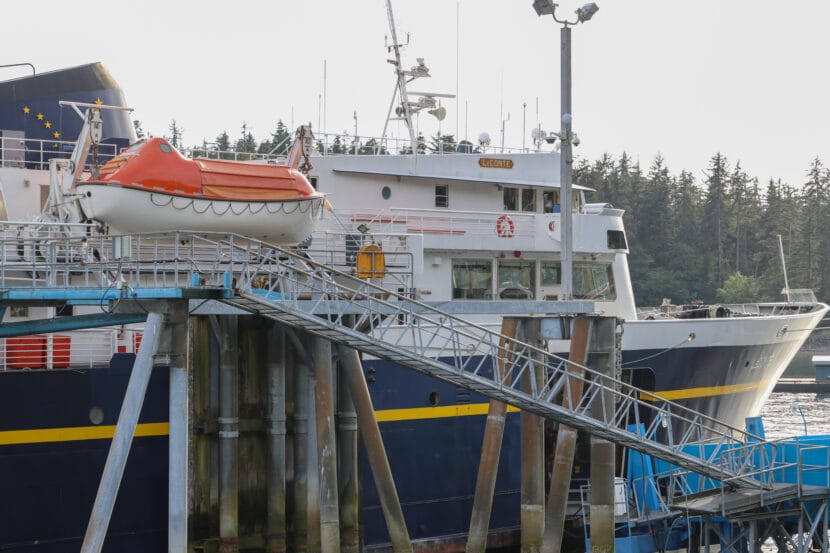 A white, blue and yellow ship with an orange raft hanging off its side. A small sign with the name "LeConte" is on the side of the ship.