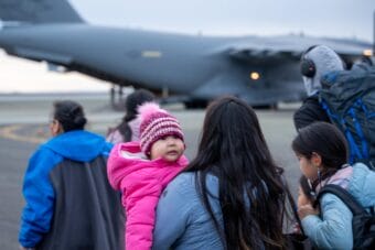 Evacuees from the village of Kipnuk walk towards a waiting C-17 military transport plane in Bethel, Alaska on Oct. 16, 2025.