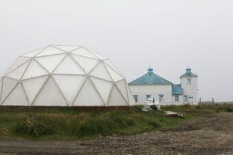 One of Nikolski's five greenhouse domes in front of St. Nicholas Church in August 2025.