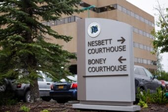 A sign with an arrow pointing right toward Nesbett Courthouse and an arrow pointing left toward Boney Courthouse.