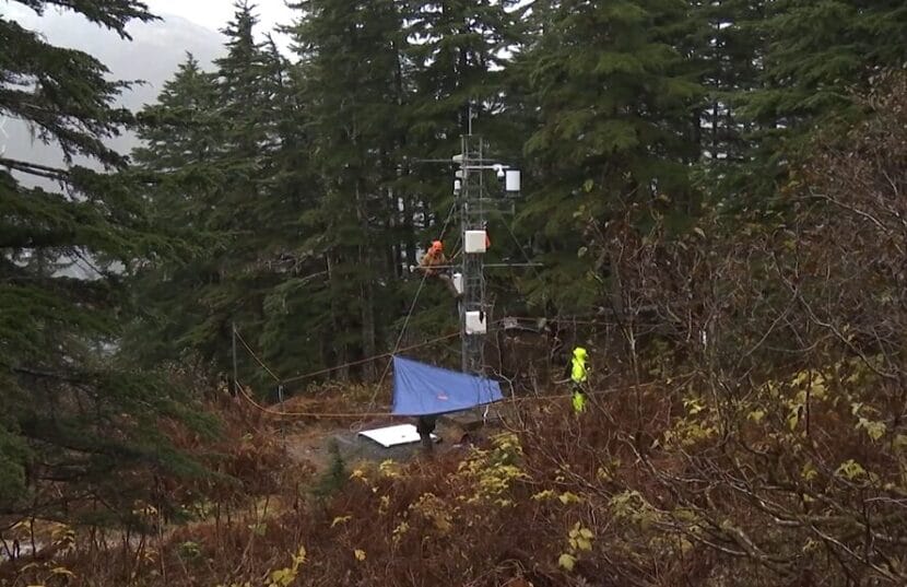 Mike Janes climbs up a weather tower to re-install snow sensors ahead of avalanche season. (Photo by Will Mader/KTOO)