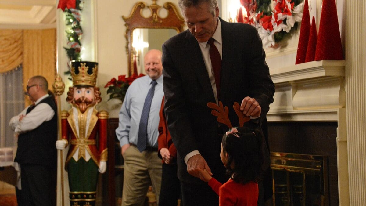 Alaska Gov. Mike Dunleavy greets a child during the governor's annual holiday open house on Tuesday, Dec. 12, 2022 at the Governor's Mansion in Juneau.