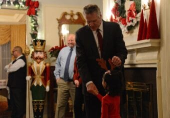 Alaska Gov. Mike Dunleavy greets a child during the governor's annual holiday open house on Tuesday, Dec. 12, 2022 at the Governor's Mansion in Juneau.
