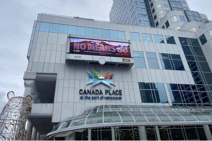An electronic billboard on the side of the Canada Place building in Vancouver displays the anti-mine message "No means go"
